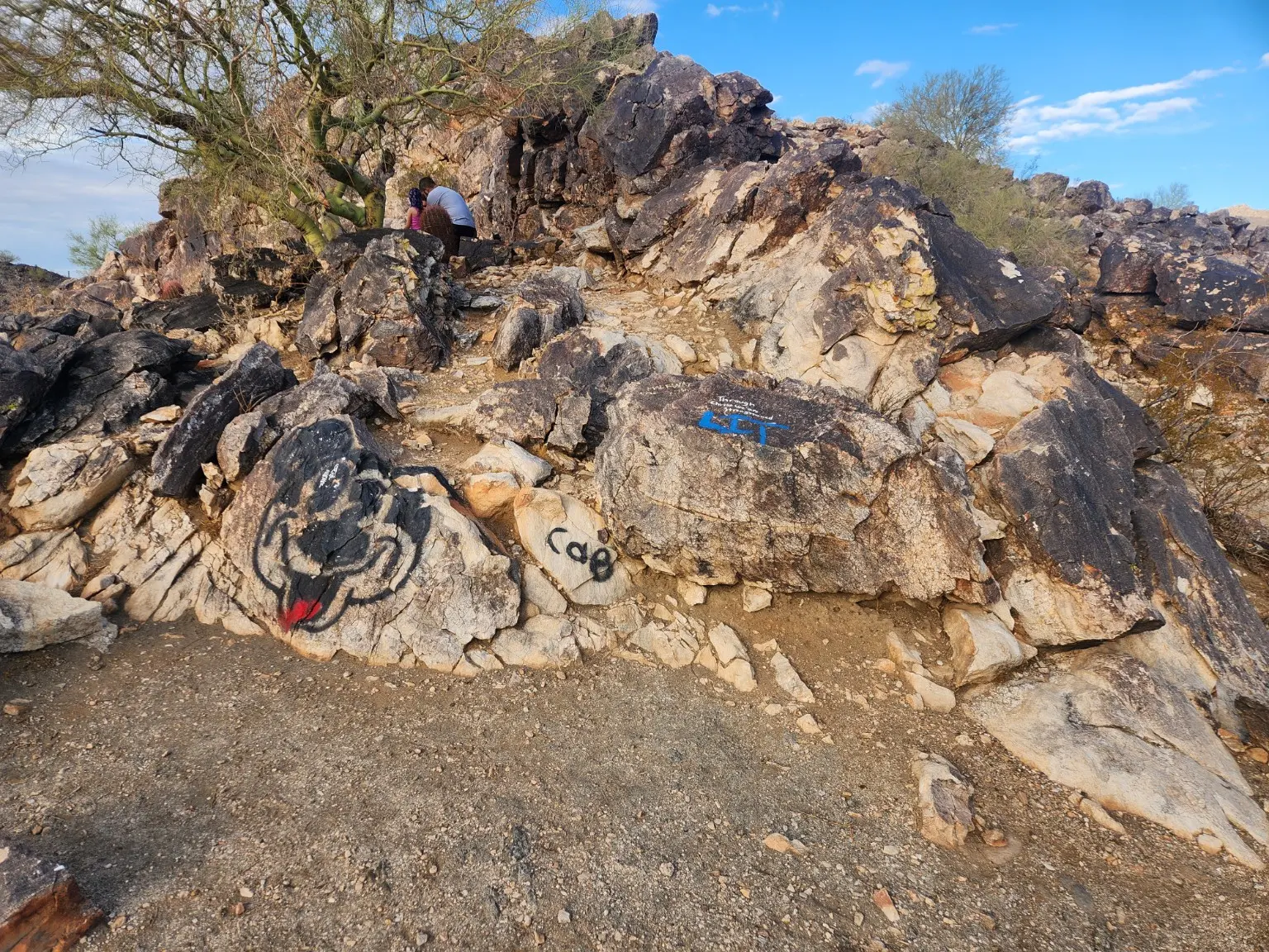 Graffiti painted on boulders beside an Arizona desert trail